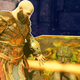 Kratos grabs at large, glowing chest that contains loot.